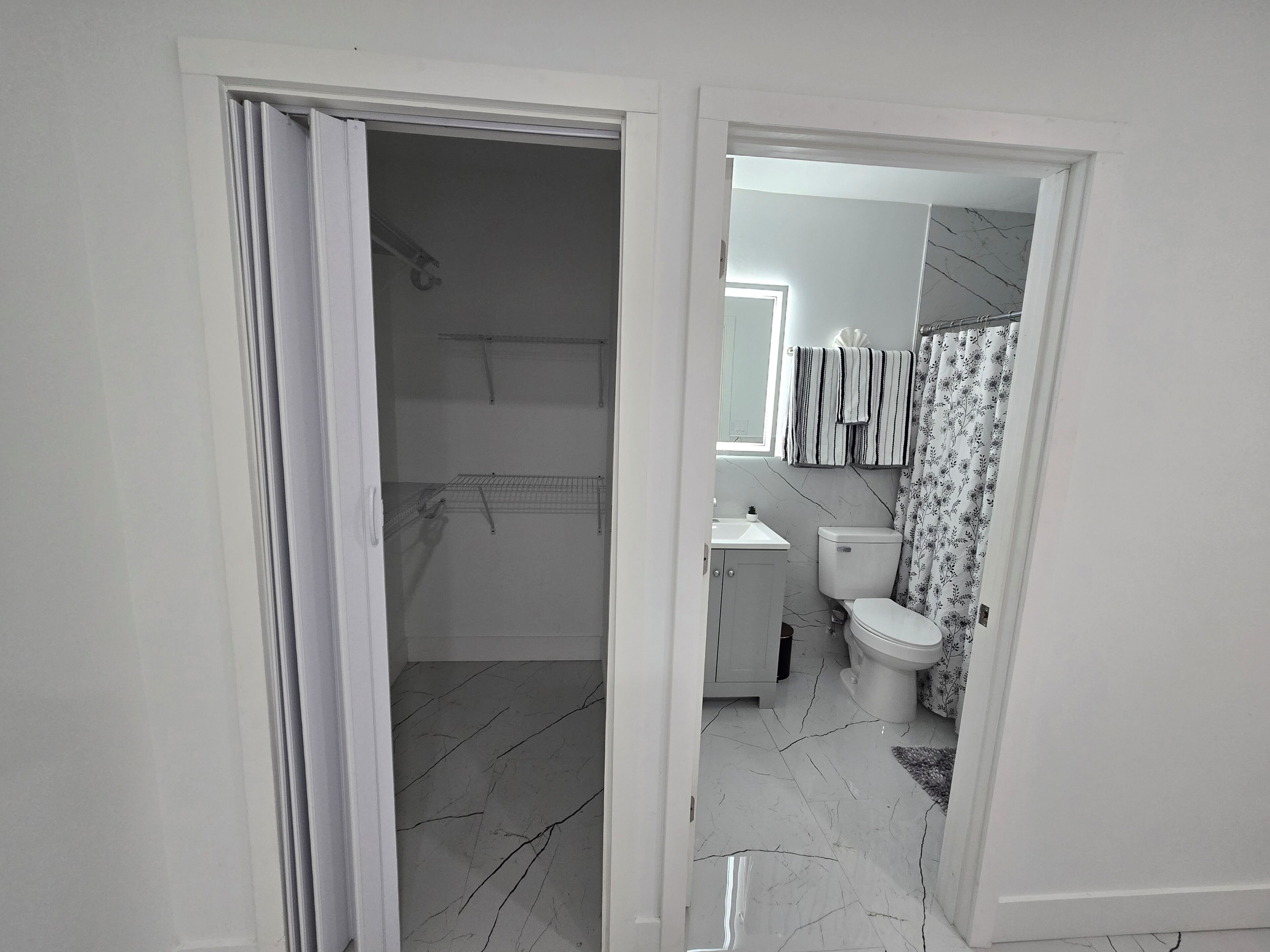 Et badeværelse med toilet, vask og bruseområde.