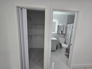 Casa de banho com sanita, lavatório e zona de duche.