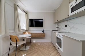 Eine kleine Küche mit Essbereich, einem Fenster und einem eingebauten Backofen.