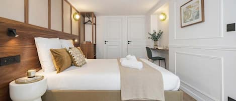 A hotel room with a large bed, bedside tables, a desk, and a chair.