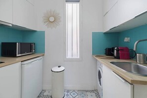 A compact kitchen with a microwave, sink, and washing machine. - Greneta - Spacious Flat Montorgueuil 4PAX (Paris)