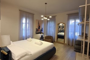 A hotel room with a bed, a chair, a desk, and a mirror. - An elegant and bright 56 ​​square meters apartment featuring a spacious patio (24 square meters)—perfect for four guests—located on the raised ground floor of a renovated building.The property is ideally situated for visiting Venice and is well-s (Venice)