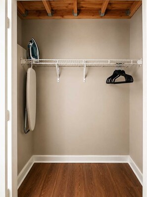 A closet with a wooden ceiling, a metal shelf, and a hanging rack. - Modern 2BR in Heart of Philly | Rafa Properties (Philadelphia)