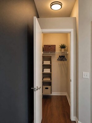A hallway leading to a closet with shelves, a basket, and a plant. - Spacious 2BR Center City Gem | By Rafa Properties (Philadelphia)