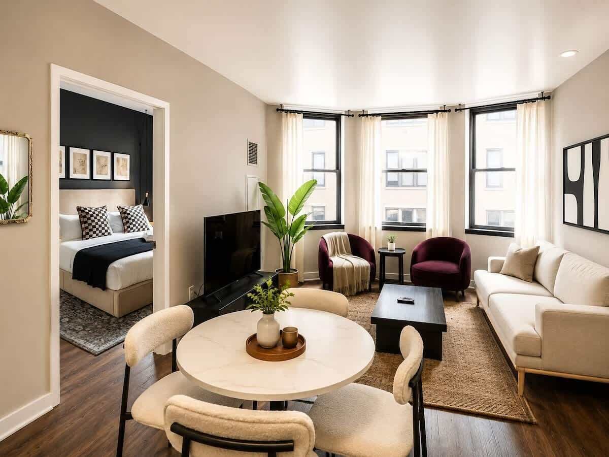 A modern living room with a sofa, armchairs, a coffee table, and a TV.