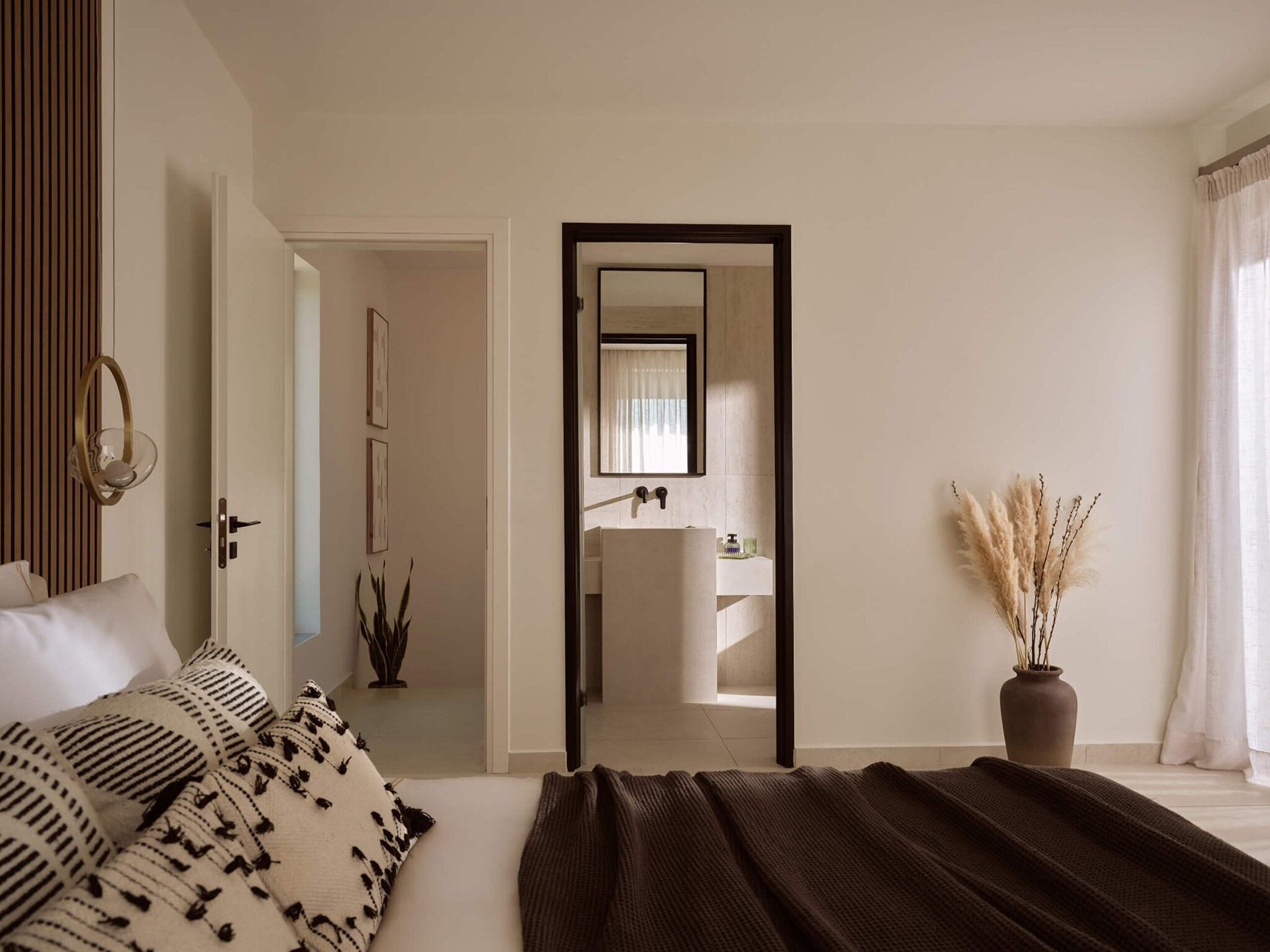 Un dormitorio con cama, mesita de noche, espejo y planta en maceta.