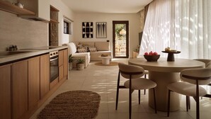 A modern kitchen with wooden cabinets, a dining area with a round table and chairs, and a living area with a sofa and a coffee table. - Villa Aelionis, Private Pool, Furnished Terrace, Zakynthos (Zakynthos)
