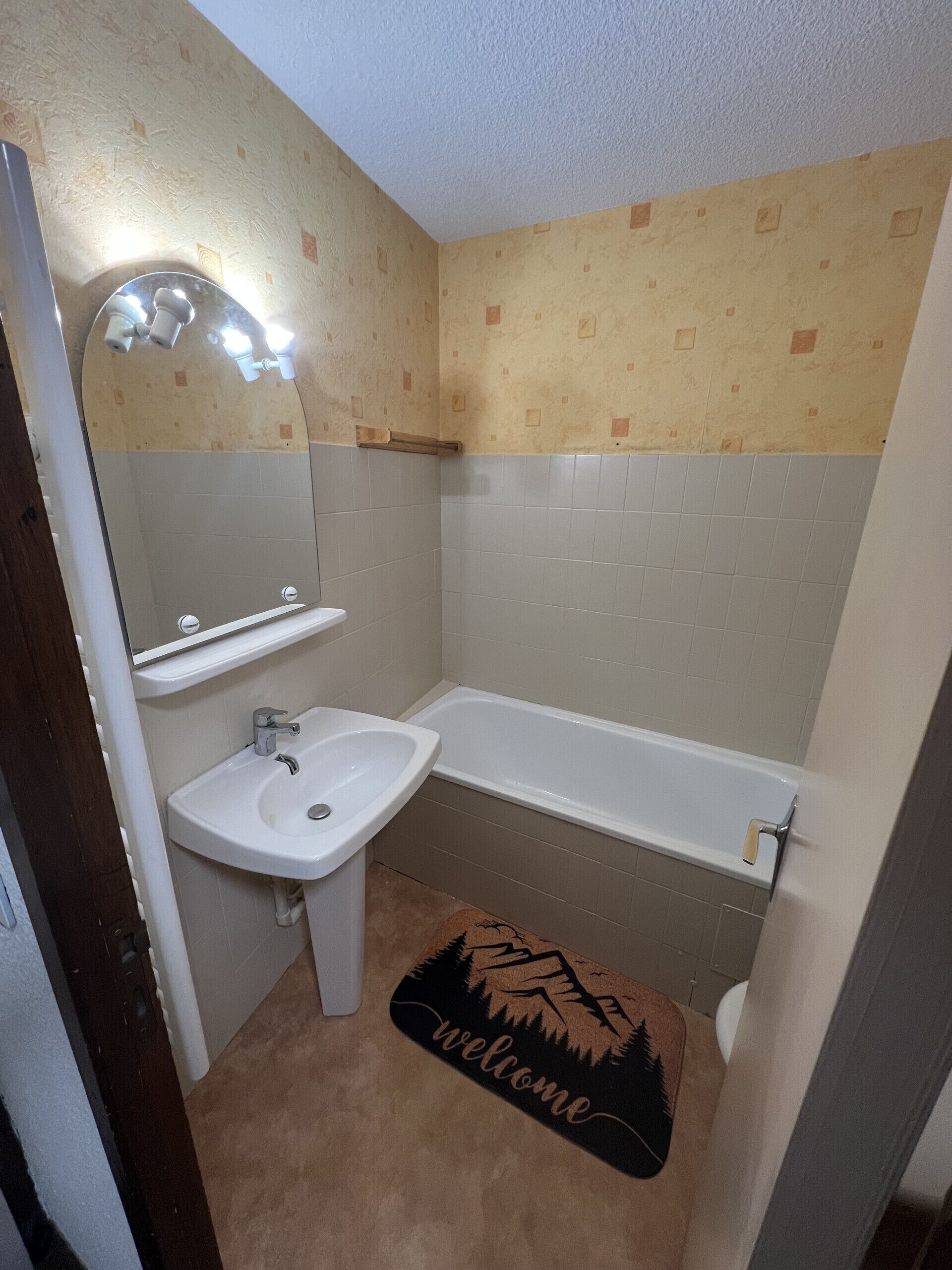 Un bagno con lavandino, specchio e vasca da bagno.
