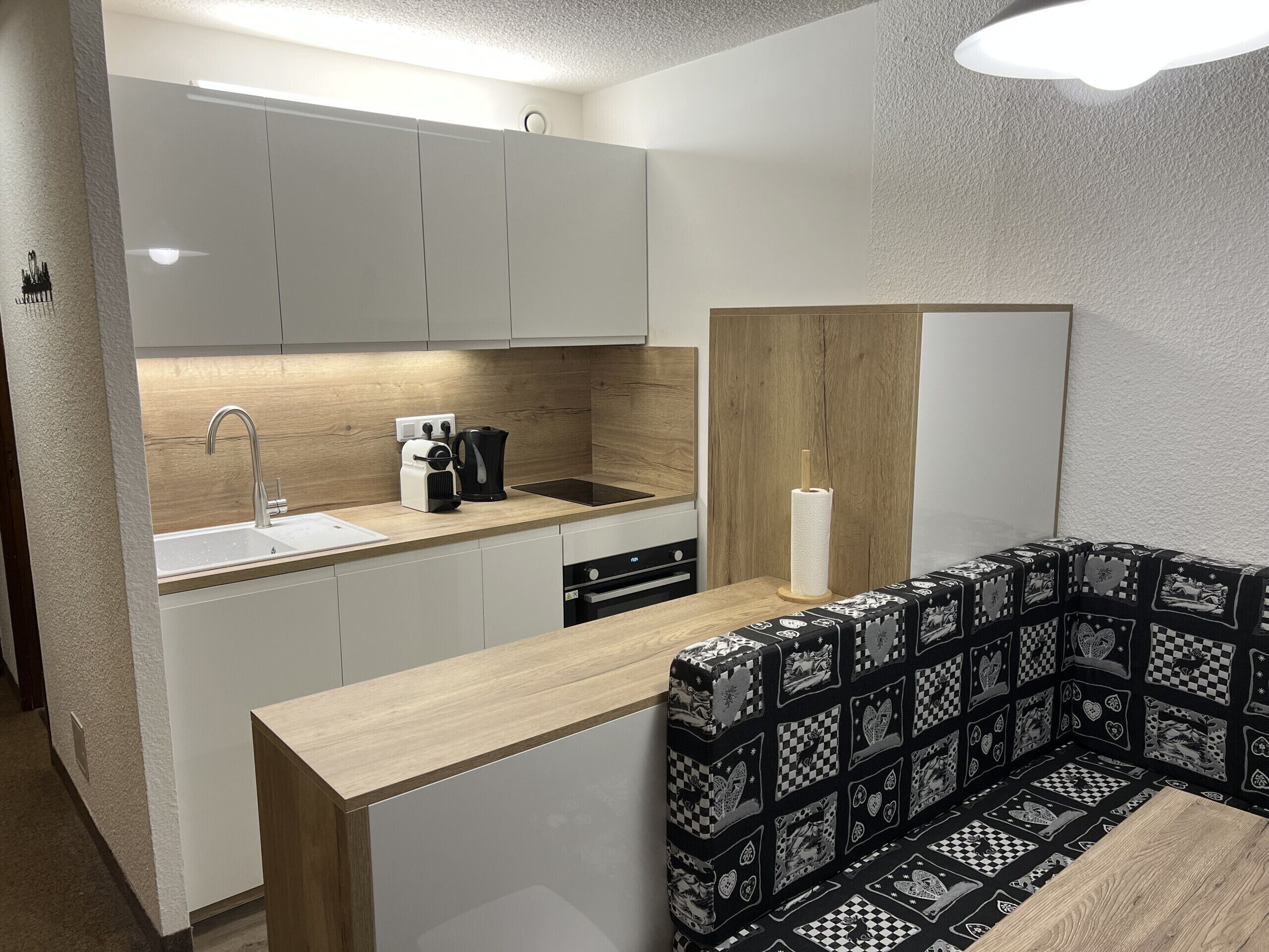 Eine moderne Küche mit Spüle, Kaffeemaschine und einer Holzarbeitsplatte.