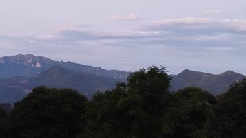 A mountain range with a red-roofed building in the foreground.