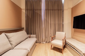 A modern room with a sofa, a chair, and a flat-screen TV mounted on the wall. - Arapanes by Bhomy (São Paulo)