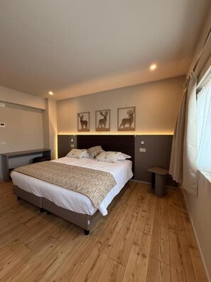 Ein Schlafzimmer mit einem Bett, Nachttischen, einer Kopfteil und Wandbildern.