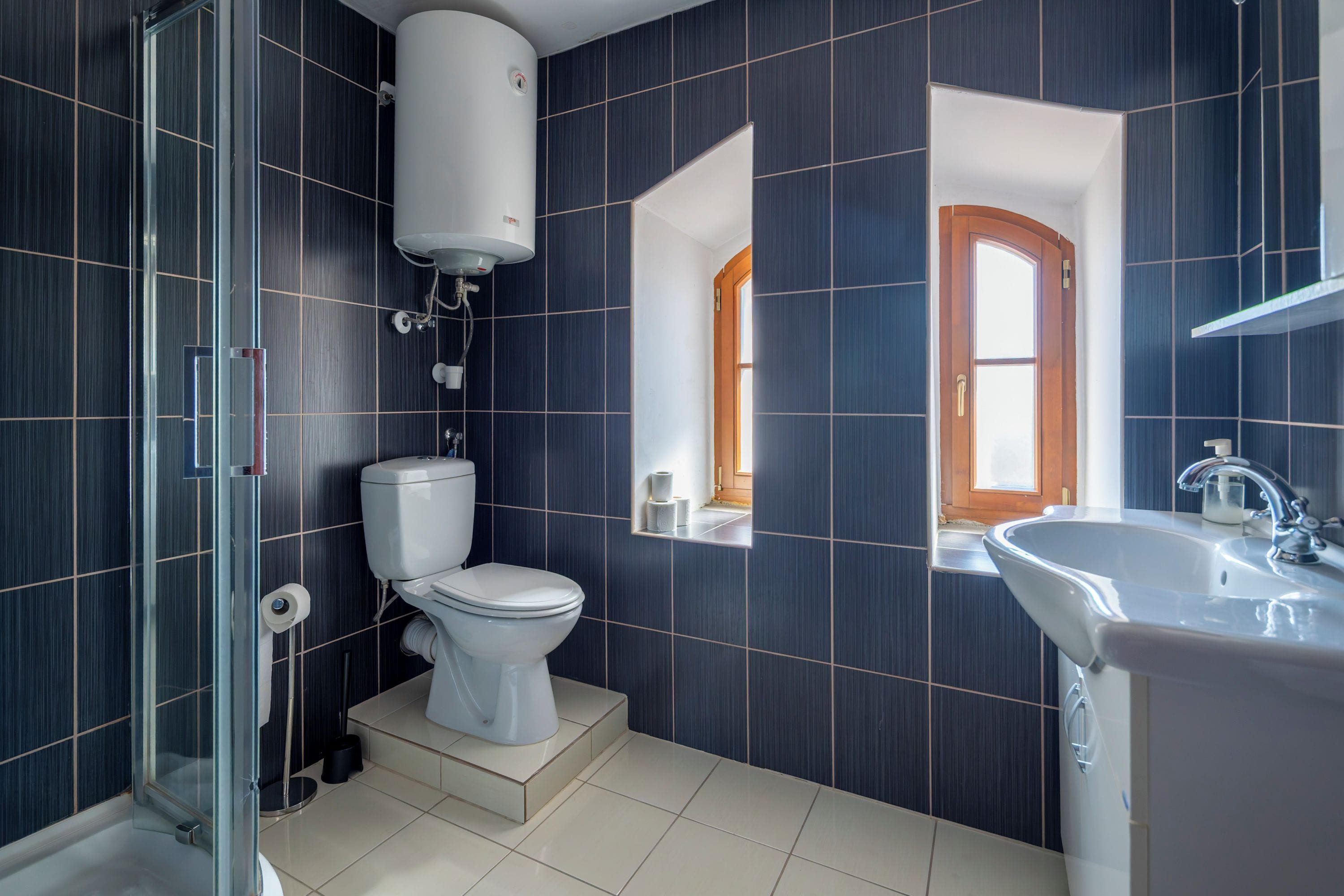 Une salle de bain moderne équipée de toilettes, d’un lavabo et d’un espace douche.