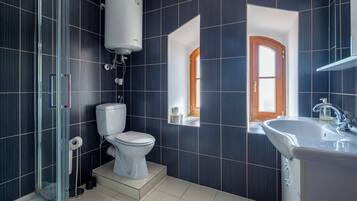 Une salle de bain moderne équipée de toilettes, d’un lavabo et d’un espace douche.