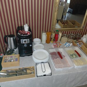 Montaje de bufé con cafetera, botellas de condimentos y recipientes de comida.