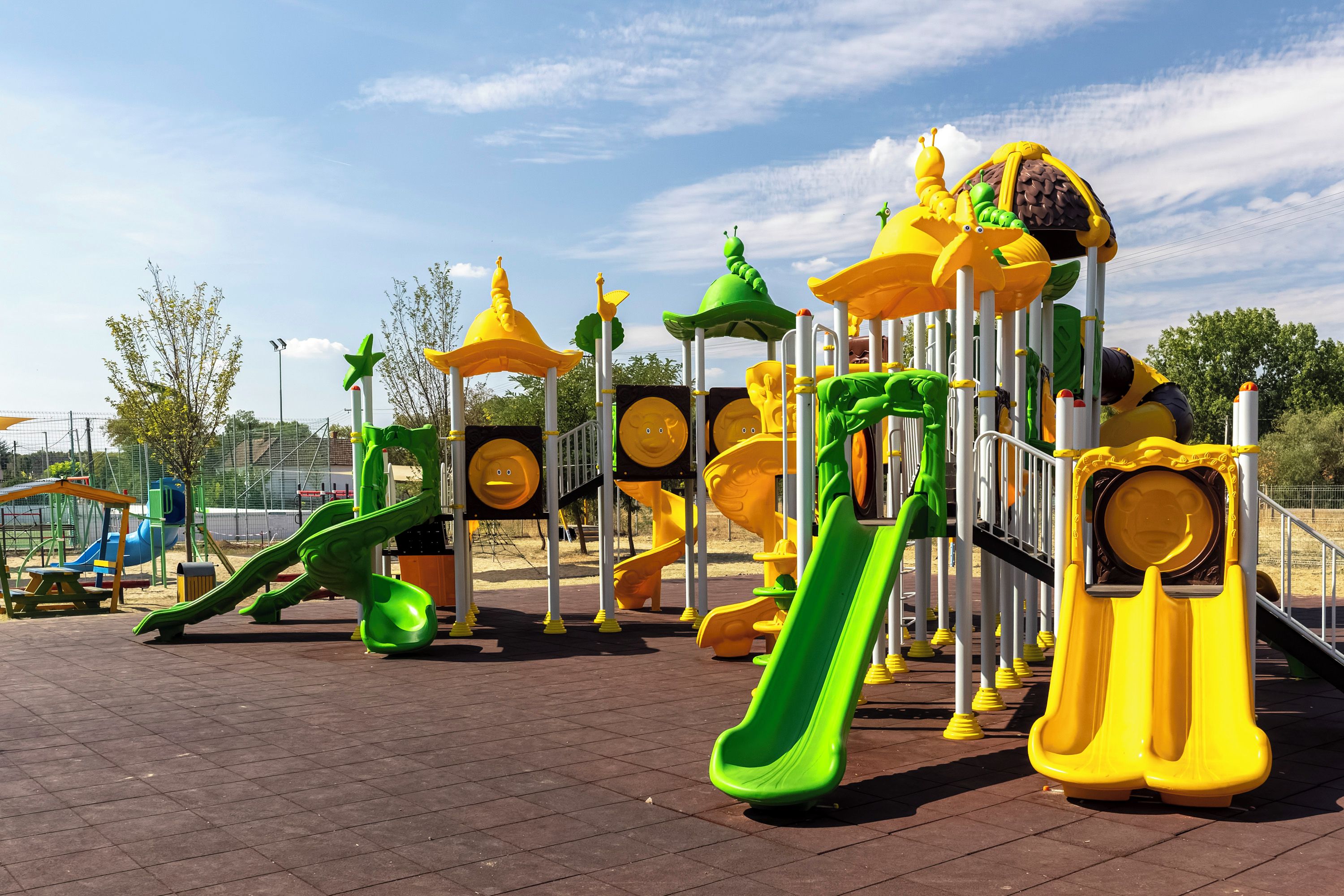 A playground with various play structures including slides and climbing areas.