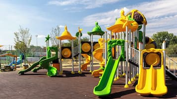 A playground with various play structures including slides and climbing areas.
