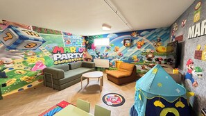 A children's playroom with a Mario-themed wall, a sofa, a small table, and a play tent. - Villa César - Private padel court, heated pool from March through November. (Bransles)