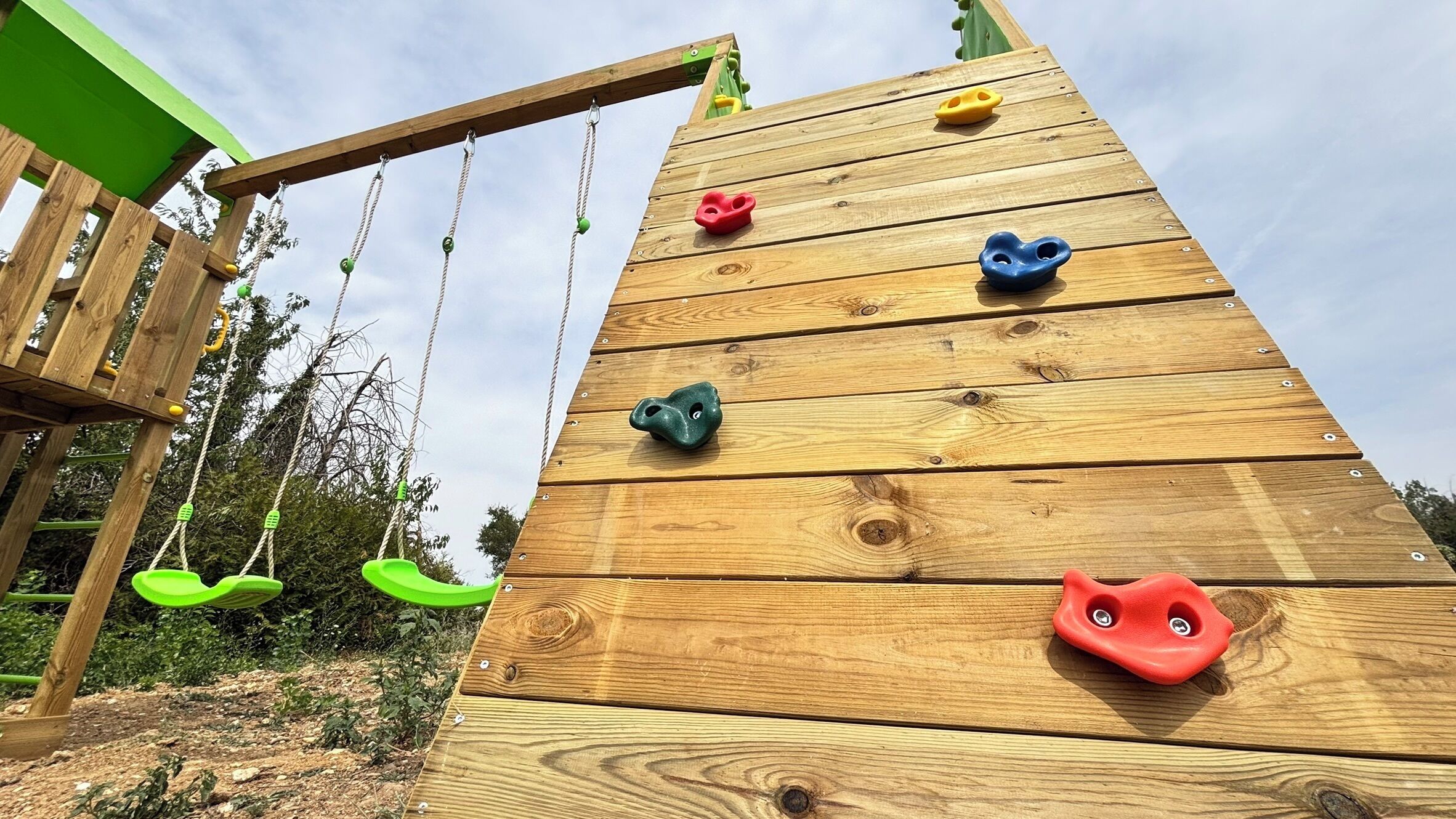 Une structure d’escalade en bois dotée de prises de différentes formes.