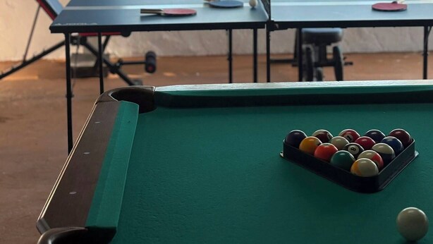 A pool table with balls and a view of a lake through a window. - 2-bedroom apartment in Sunny Freeport with cool AC. Across from Beach. (Freeport)