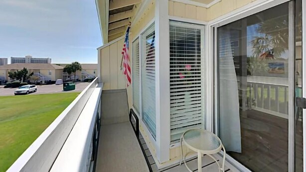 Ein Balkon mit Blick auf einen Parkplatz, eine amerikanische Flagge und eine Schiebetür.