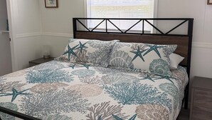 A bedroom with a bed, a ceiling fan, a window with blinds, and a framed picture on the wall. - Perfect 3-bedroom2-bath house in the heart of Crystal River. (Crystal River)