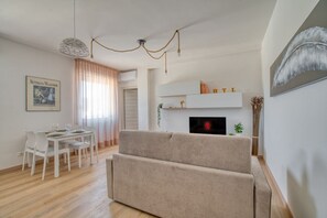 Una sala de estar moderna con un sofá, una mesa de comedor y una chimenea.