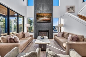 A modern living room with two sofas, a coffee table, and a fireplace. - Luxury Roof Top Cabin! Splashing Views! Pool! Hot Tub! Gaming Simulator! (Sevierville)