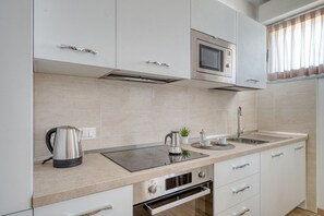 Uma cozinha moderna com micro-ondas, chaleira e forno embutidos.