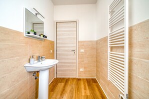 Ein Badezimmer mit Waschbecken, Spiegel und Handtuchhalter.