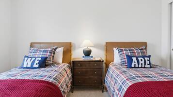 Een slaapkamer met twee bedden, een nachtkastje, een lamp en een bordje op het nachtkastje.