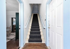 Eine Treppe mit Geländer, Teppichstufen und Holzdielen.