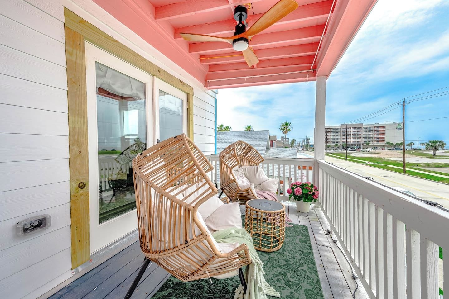 A covered porch with wicker furniture, a ceiling fan, and a view of the street.