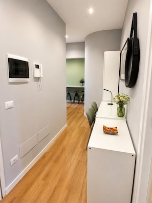 A modern kitchen with a microwave, a telephone, and a flat-screen TV mounted on the wall. - Domus Mea San Giovanni (Roma)