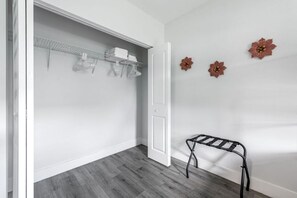 Ein Zimmer mit Schrank, kleinem Tisch und Wandblumen.