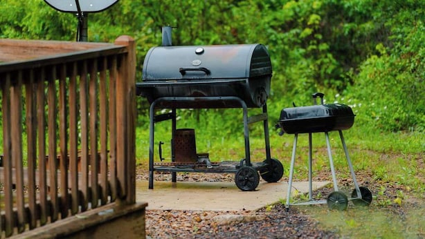 Una parrilla portátil con ruedas, una antena parabólica y un contenedor metálico.