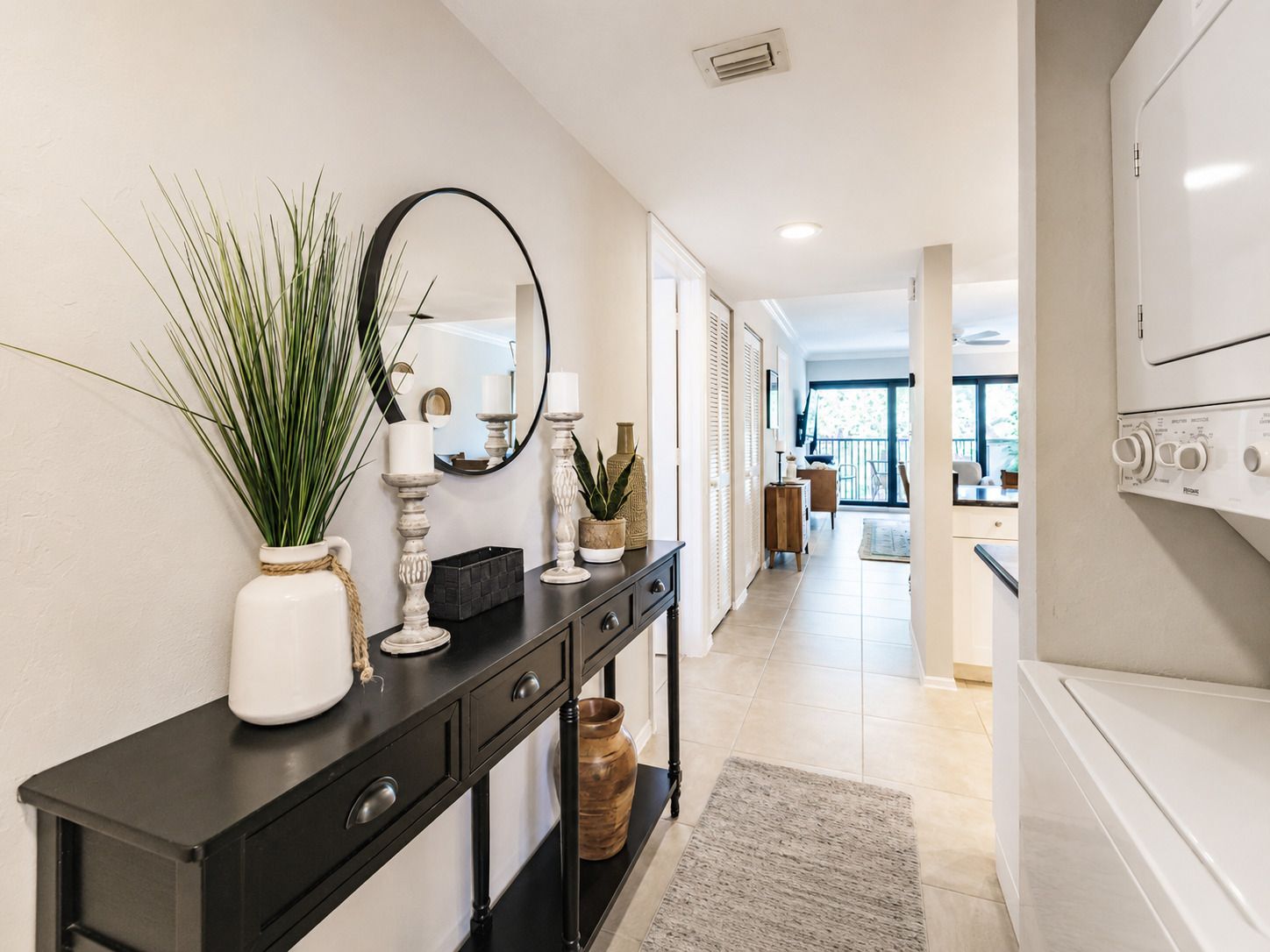 A modern kitchen with a built-in oven, a black countertop, and a large window.