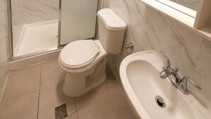 A modern bathroom with a glass-enclosed shower, a toilet, and a sink with a mirror above. - 101 HOTEL Manhattan New York City (New York)