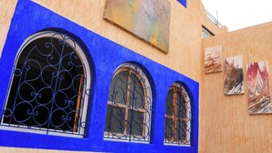A building with three arched windows with ornate metal grilles, painted in blue. - Seaview Apartment, Balcony, Great Location (Mirleft)