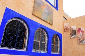 A building with three arched windows with ornate metal grilles, painted in blue. - Seaview Apartment, Balcony, Great Location (Mirleft)