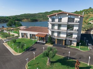 Un edificio moderno con techo plano, un balcón y vistas a un lago.