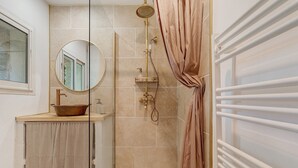 A bathroom with a bathtub, a shower, a sink with a vessel basin, a mirror, and a towel rack. - Holiday Home 'Maison En Pierre Chevaux' with Wi-Fi (Puyvert)