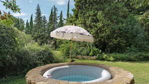 A hot tub with a decorative umbrella in a natural setting. - Holiday Home 'Maison En Pierre Chevaux' with Wi-Fi (Puyvert)