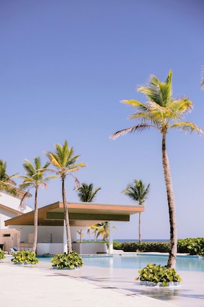 Un resort con piscina, palmeras y un edificio de diseño moderno.