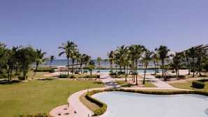 Un resort con piscina, palmeras y vista al océano.