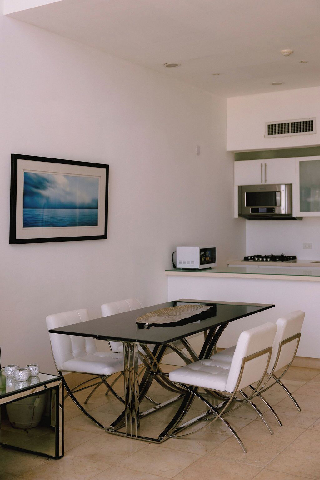 A modern kitchen with white cabinets, a microwave, and a gas stove.
