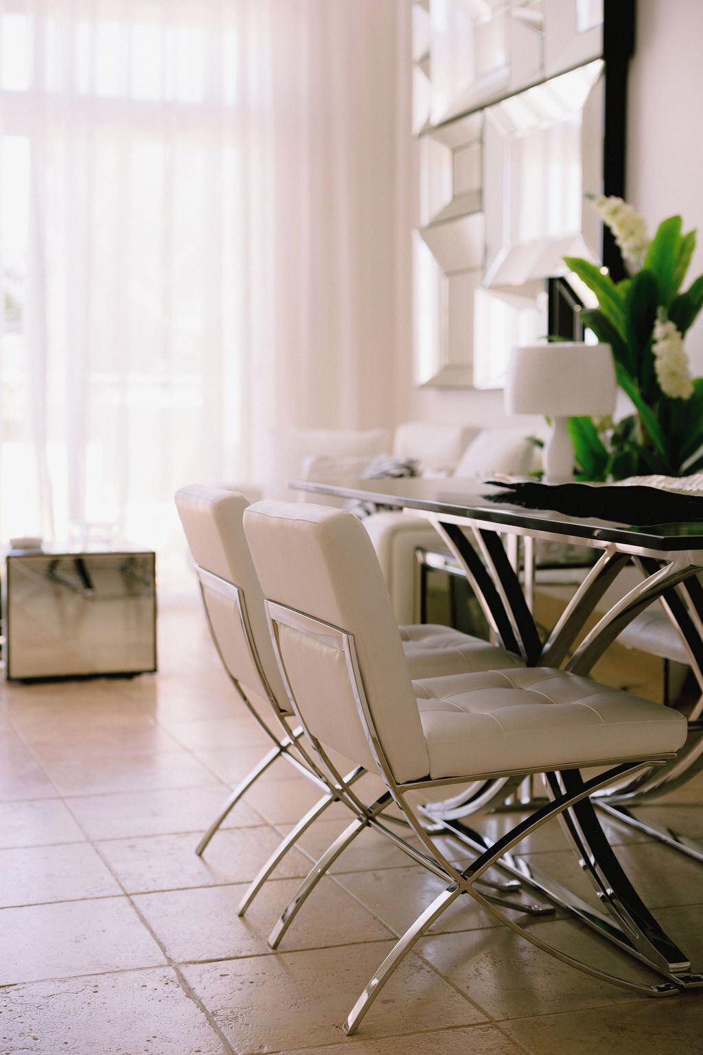 A dining area with a round table and four chairs with a metallic frame.