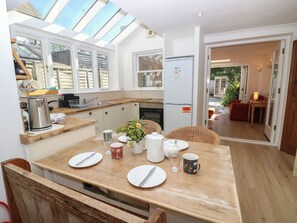 A modern kitchen with a dining area, a built-in oven, and a refrigerator. - Merrilees (Yarmouth)