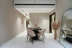 Un espace repas moderne avec une table ronde, des chaises et un miroir.