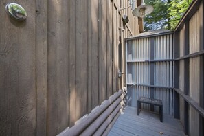 A wooden deck with a metal railing, a bench, and a wall-mounted light fixture. - (2027 OPEN!) Gorgeous Union Pier Home With Private Pool! (Union Pier)